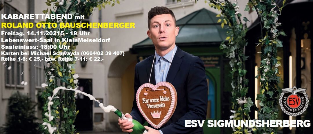 Ein Mann hält eine Champagnerflasche und hat einen herzförmigen Keks auf der Brust. Der Keks sagt 'Für meine kleine Prinzessin'. Der Mann trägt einen Anzug.