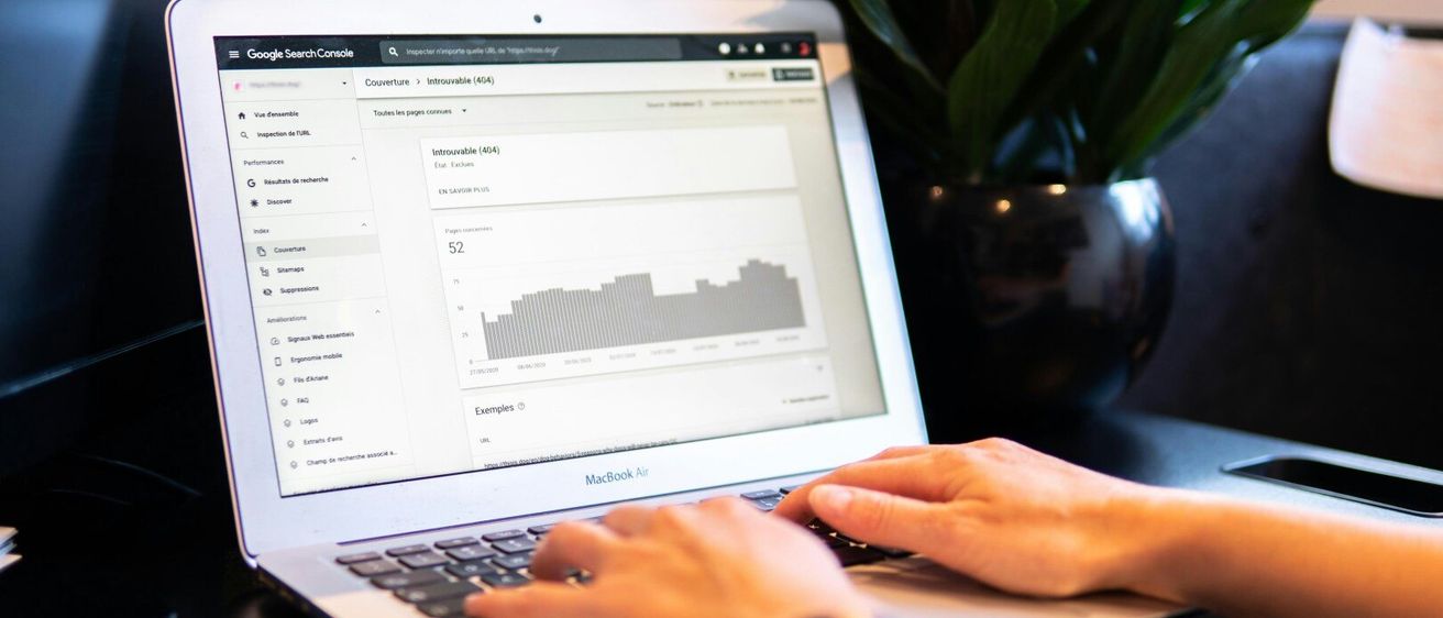 Eine Person tippt auf einem MacBook Air Laptop. Der Laptop-Bildschirm zeigt eine Google Search Console-Seite mit 52 nicht crawlbaren URLs an.