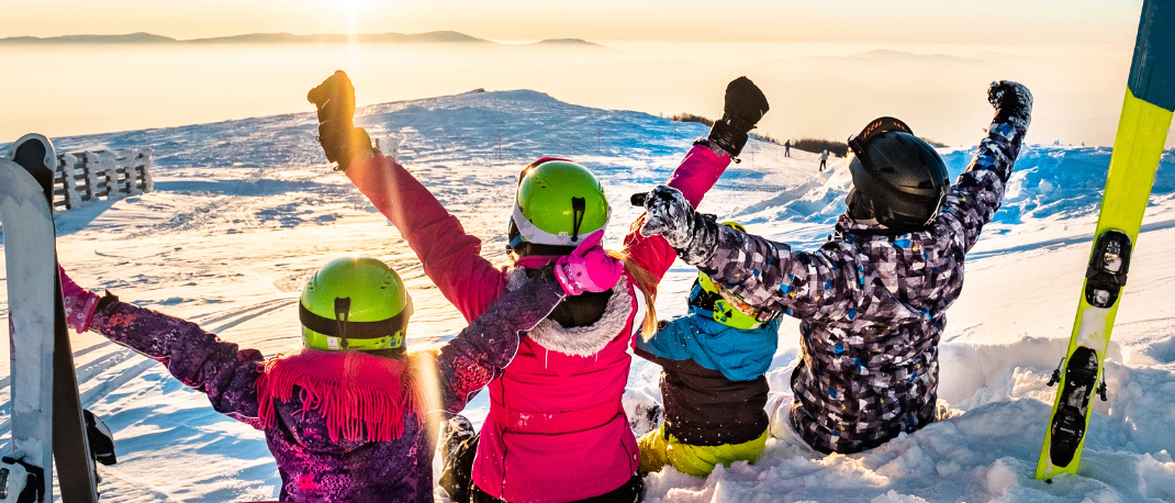 Fünf Kinder in Winterkleidung posieren für ein Foto auf einem verschneiten Berg bei Sonnenuntergang. Skier und Helme sind sichtbar. Die Daten 17.01. und 19.02.2026 sind im Bild angezeigt.