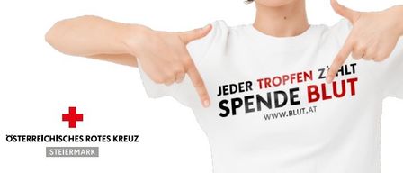 Eine Person zeigt auf ein weisses T-Shirt mit dem Text 'Jeder Tropfen Zählt SPENDEN BLUT WWW.BLUT.AT'. Darunter befindet sich ein rotes Kreuz-Symbol mit 'Oösterreichisches Rotes Kreuz' und 'Steiermark'.