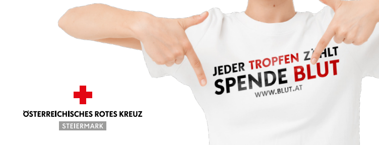 Eine Person zeigt auf ein weisses T-Shirt mit 'Jeder Tropfen Zählt' und 'Spende Blut', darunter ein rotes Kreuz. Das T-Shirt gehört zum Österreichischen Roten Kreuz.