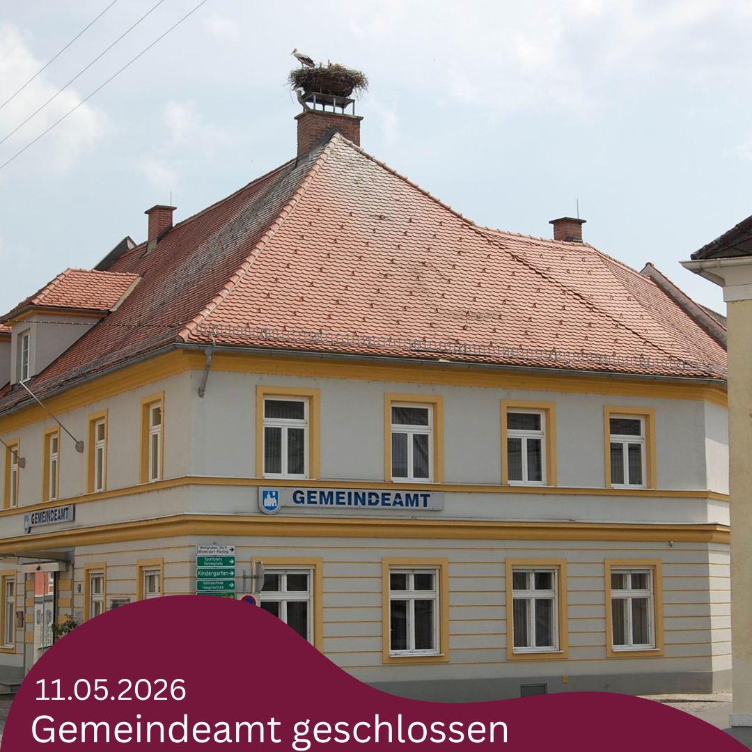 Ein zweistöckiges Gebäude mit rotem Dach, weißen Wänden und gelbem Rand. Ein Vogelnest ist auf dem Schornstein. Das Datum 11.05.2026 und die Worte Gemeindeamt geschlossen werden angezeigt.