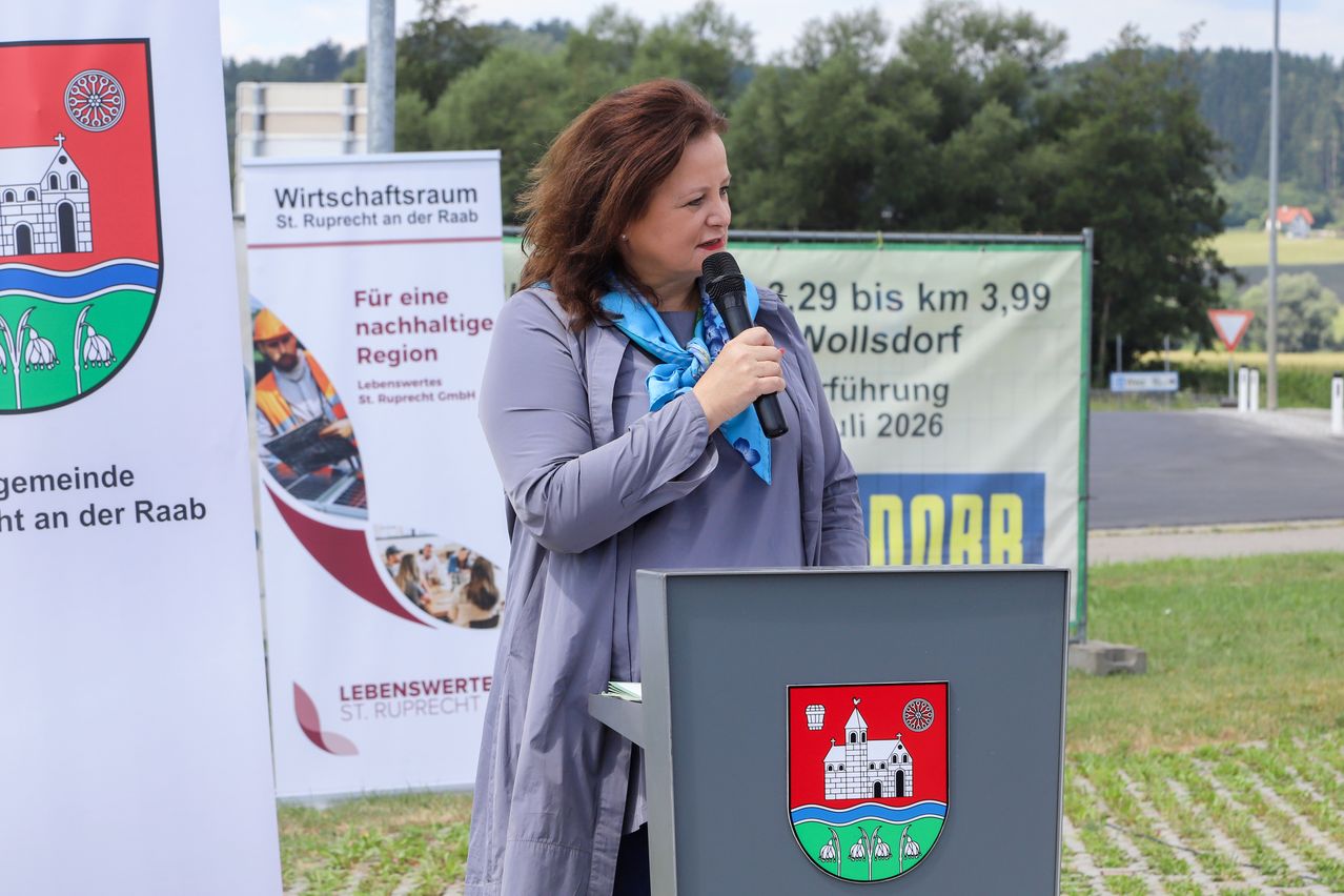 Frau mit Mikrofon in St. Ruprecht an der Raab, Österreich, vor Werbebannern