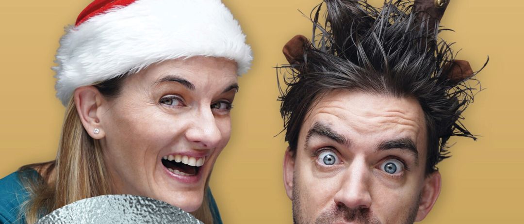 Zwei Personen in festlicher Kleidung, eine mit Weihnachtsmütze, die andere mit Rentiergeweih, lächeln. Gelber Hintergrund mit 'Gluecklich' und 'Be Quadrat'. Veranstaltung am 29.11.2025.