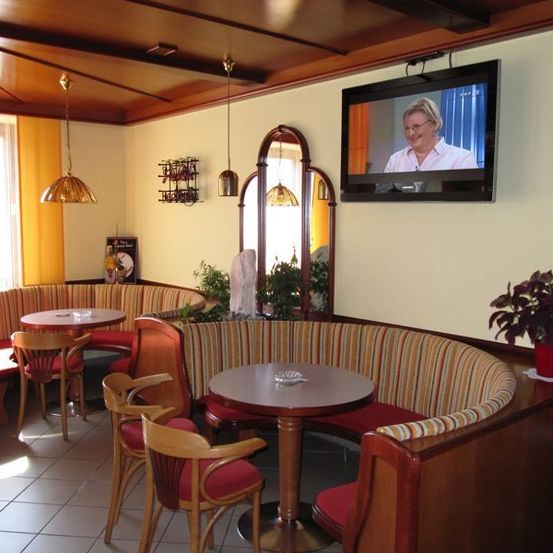 Bild enthält, Computer Hardware, Hardware, Monitor, Screen, TV, Dining Table, Table, Living Room, Interior Design, Chair