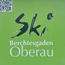 Ein grünes Plakat mit einem QR-Code und stilisiertem Text, der 'Ski Berchtesgaden Oberau' lautet. Der QR-Code befindet sich auf der linken Seite.