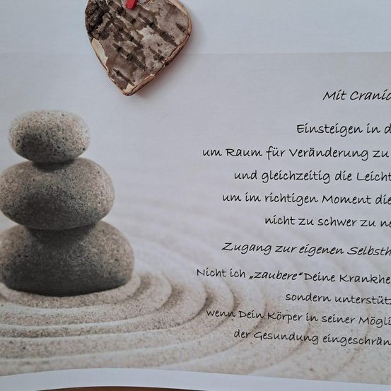 Eine Karte mit einem Herz-Design oben darauf zeigt einen Steinstapel mit einem Zitat in deutscher Sprache. Das Zitat bedeutet übersetzt 'Einsteigen in den Raum für Veränderung und gleichzeitig die Leichtigkeit, um im richtigen Moment nicht zu schwer zu sein.'