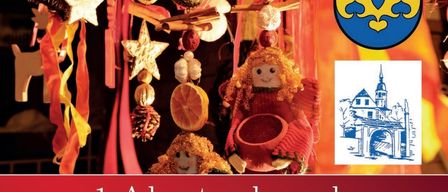 Eine Werbung für eine Weihnachts- und Krippenausstellung am ersten Adventwochenende. Es zeigt ein blaues Kreuzlogo und verschiedene Ornamente. Die Termine sind der 29. und 30. November.