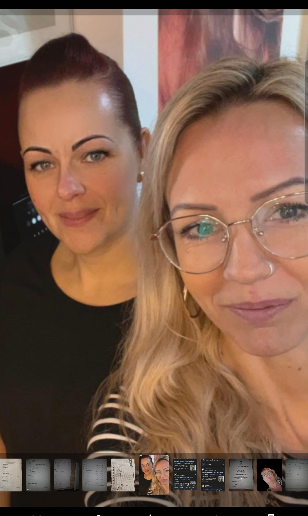 Zwei Frauen stehen eng beieinander. Eine hat braune Augen und eine Brille, während die andere grüne Augen hat. Beide lächeln.