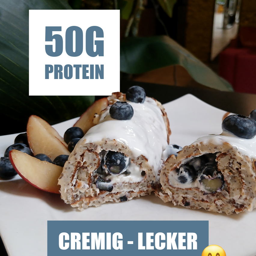 A plate with two slices of a blueberry and cream-filled roll, topped with blueberries and a white cream. The roll is cut in half, showing the inside. The plate is placed on a white surface. The image has a watermark with the text '50G PROTEIN' and a smiley face.