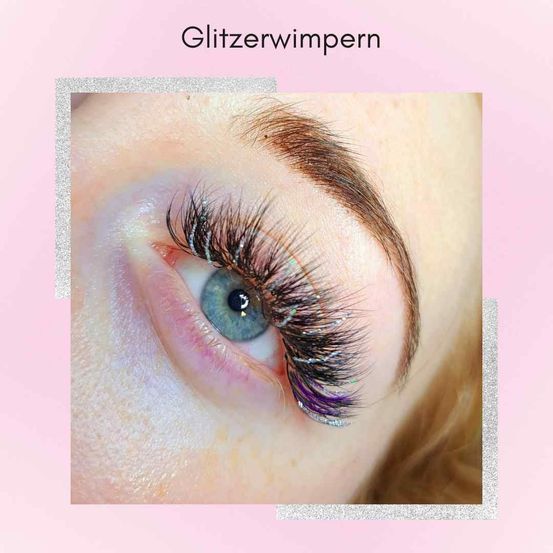 Nahaufnahme eines Augens, das ein Paar glamouröser, glitzernder künstlicher Wimpern zeigt. Die Wimpern sind lang, voluminös und haben einen schimmernden Effekt. Das Auge ist mit Wimperntusche betont und die Wimpern sind dramatisch gestylt.