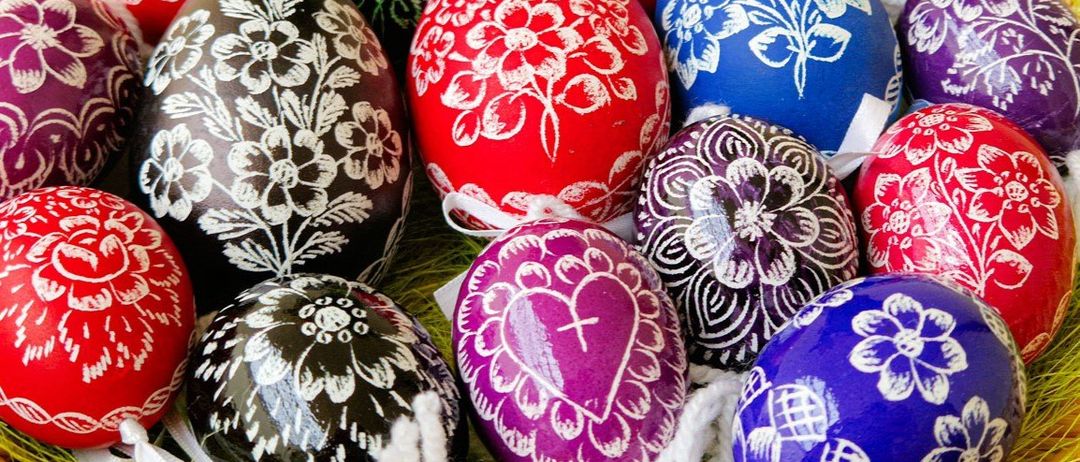 Dekorierte Ostereier in verschiedenen Farben mit Blumen- und Herzdesigns werden in einer Nahaufnahme gezeigt.