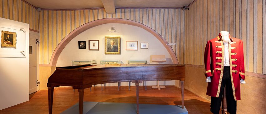 Bild enthält, Floor, Flooring, Indoors, Interior Design, Wood, Hardwood, Coat, Grand Piano, Musical Instrument, Person