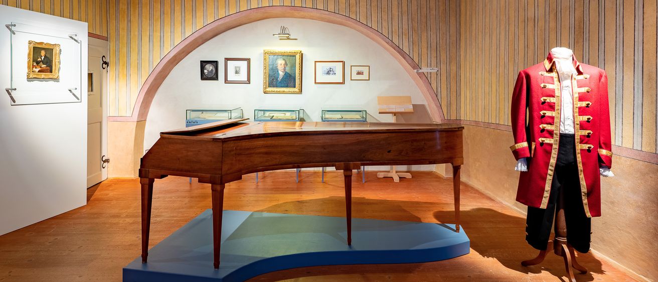 Bild enthält, Floor, Flooring, Indoors, Interior Design, Wood, Coat, Hardwood, Person, Grand Piano, Building