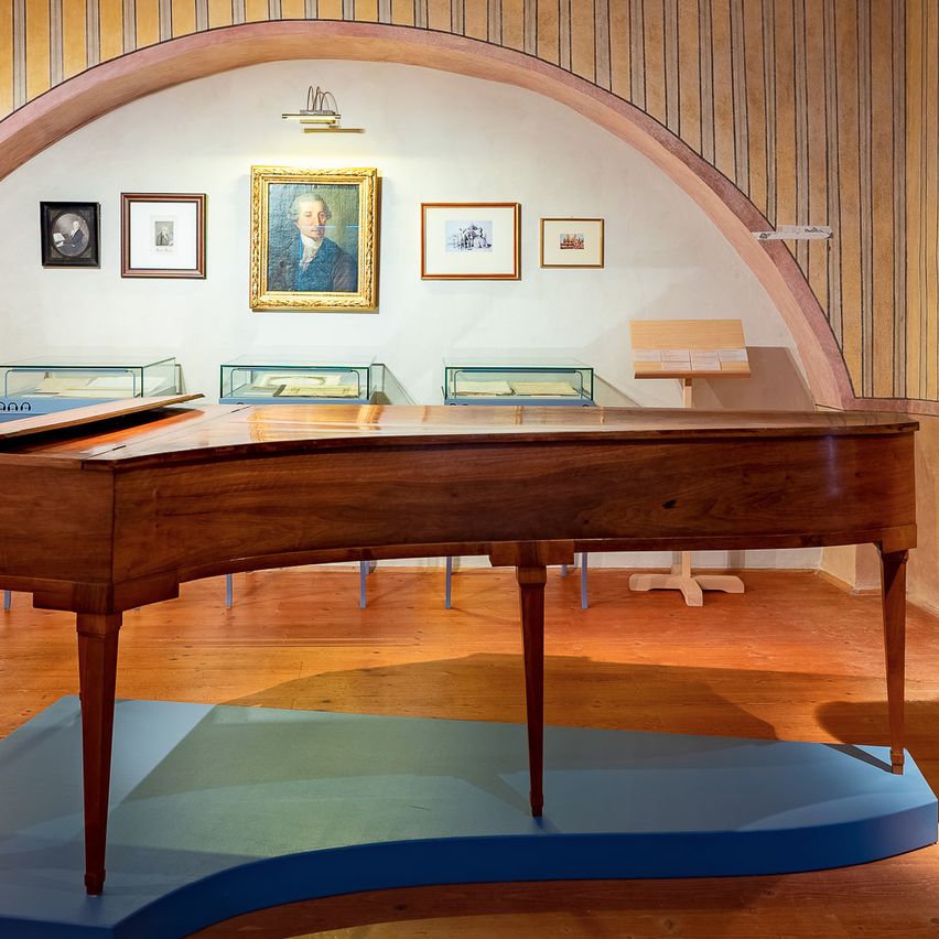 Bild enthält, Floor, Flooring, Indoors, Interior Design, Wood, Coat, Hardwood, Person, Grand Piano, Building