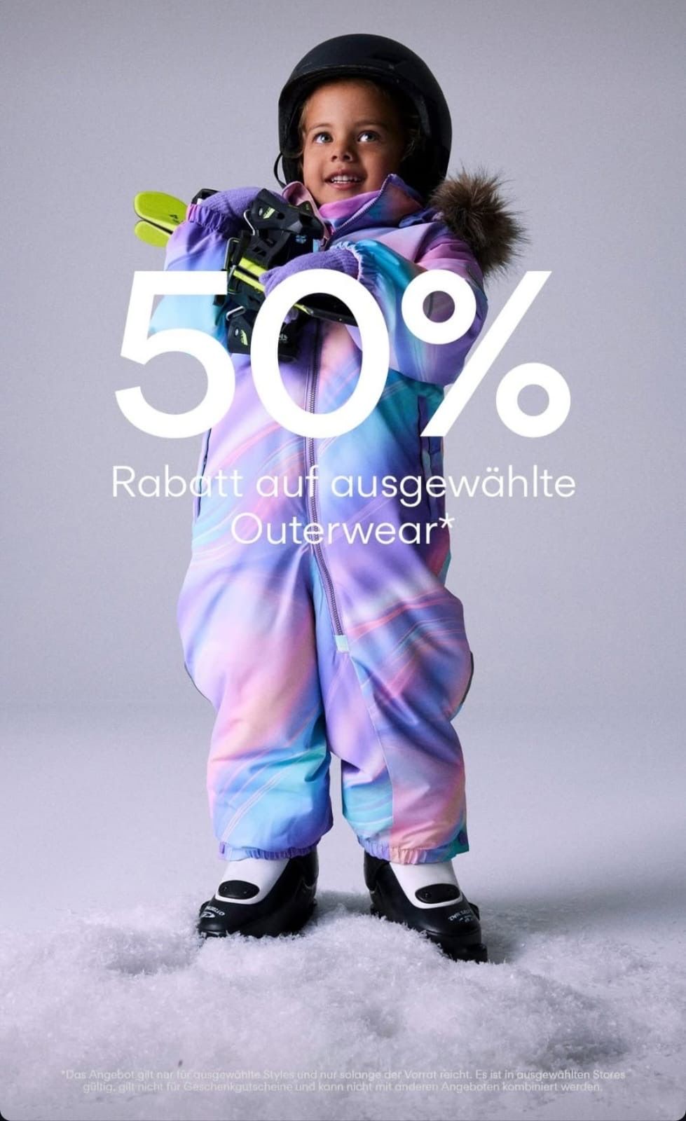 Eine Person steht in einem farbenfrohen Outfit, hält Skier und scheint einen 50%igen Rabatt auf ausgewählte Oberbekleidung zu bewerben.