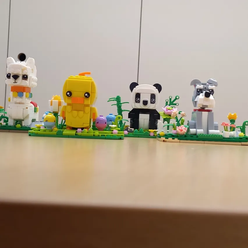 Eine Sammlung von Lego-Figuren auf einem Tisch, darunter eine Ente, ein Panda, ein Hund und ein Schaf.