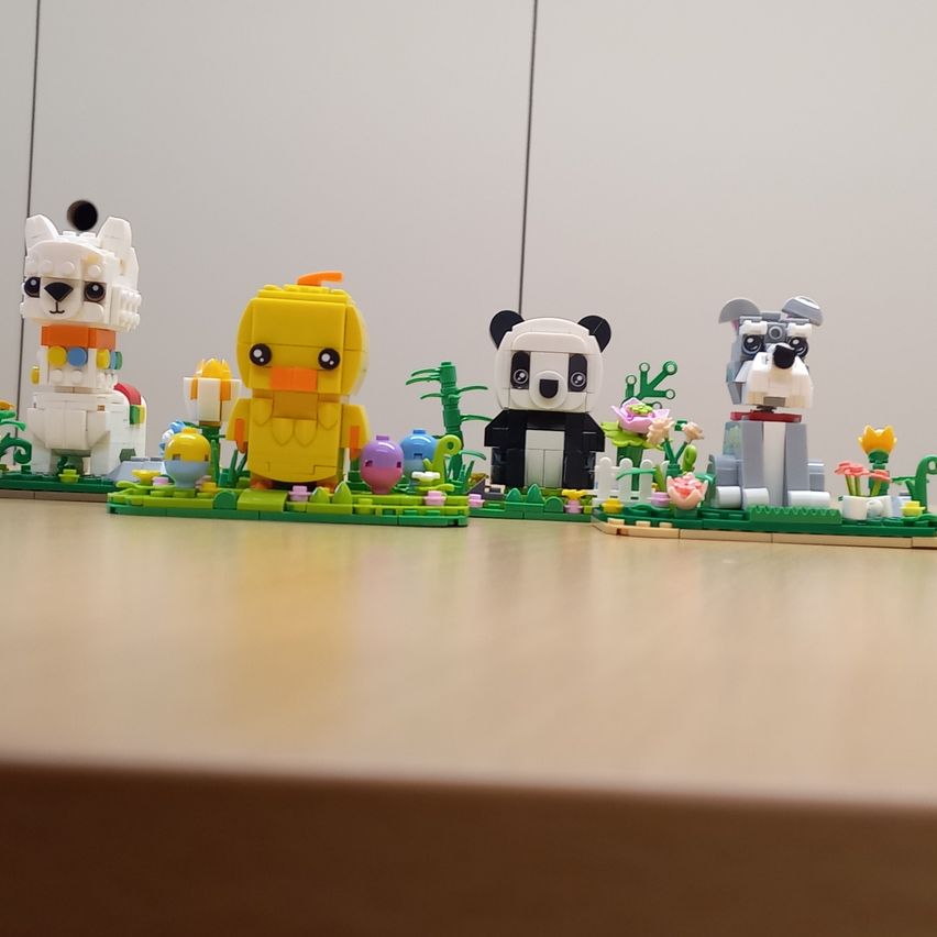 Eine Sammlung von Lego-Figuren auf einem Tisch, darunter eine Ente, ein Panda, ein Hund und ein Schaf.