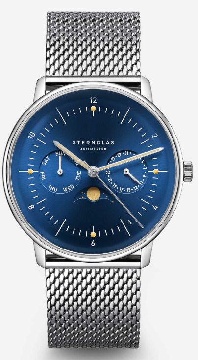 Eine blaue Armbanduhr mit einem silbernen Mesh-Armband, ausgestattet mit einem silbernen Zifferblatt, das 'STERNGLAS ZEITMESSER' und eine Mondphasenanzeige zeigt. Die Uhr hat eine Datumsanzeige und ist mit Zahlen von 1 bis 31 versehen.
