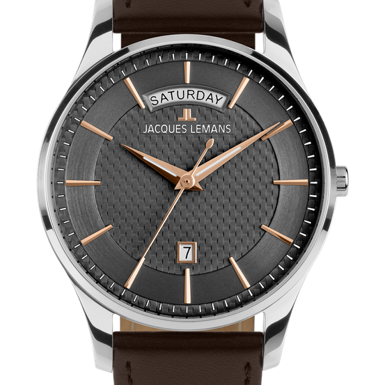 Die Uhr hat ein silberfarbenes Metallgehäuse mit einem schwarzen Zifferblatt. Es zeigt den Tag als Samstag, den Markennamen Jacques Lemans und die Zahl 7. Die Zeiger sind golden.