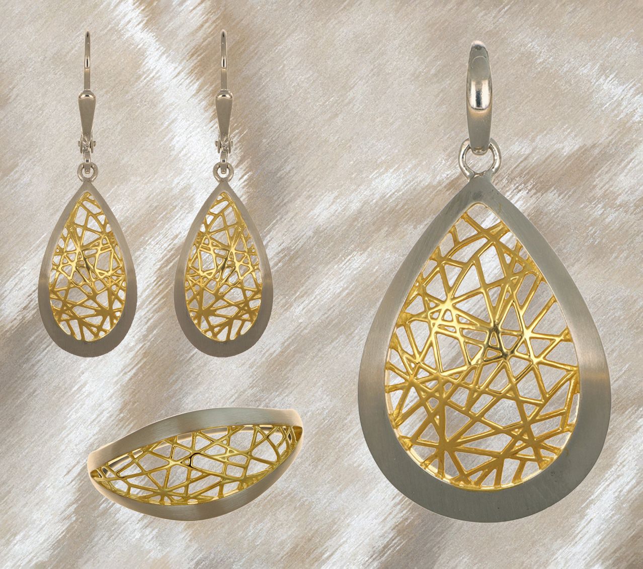 Ein Set aus drei silbernen und goldenen Ohrringen mit komplizierten geometrischen Mustern, die auf einem beigen Hintergrund präsentiert werden.