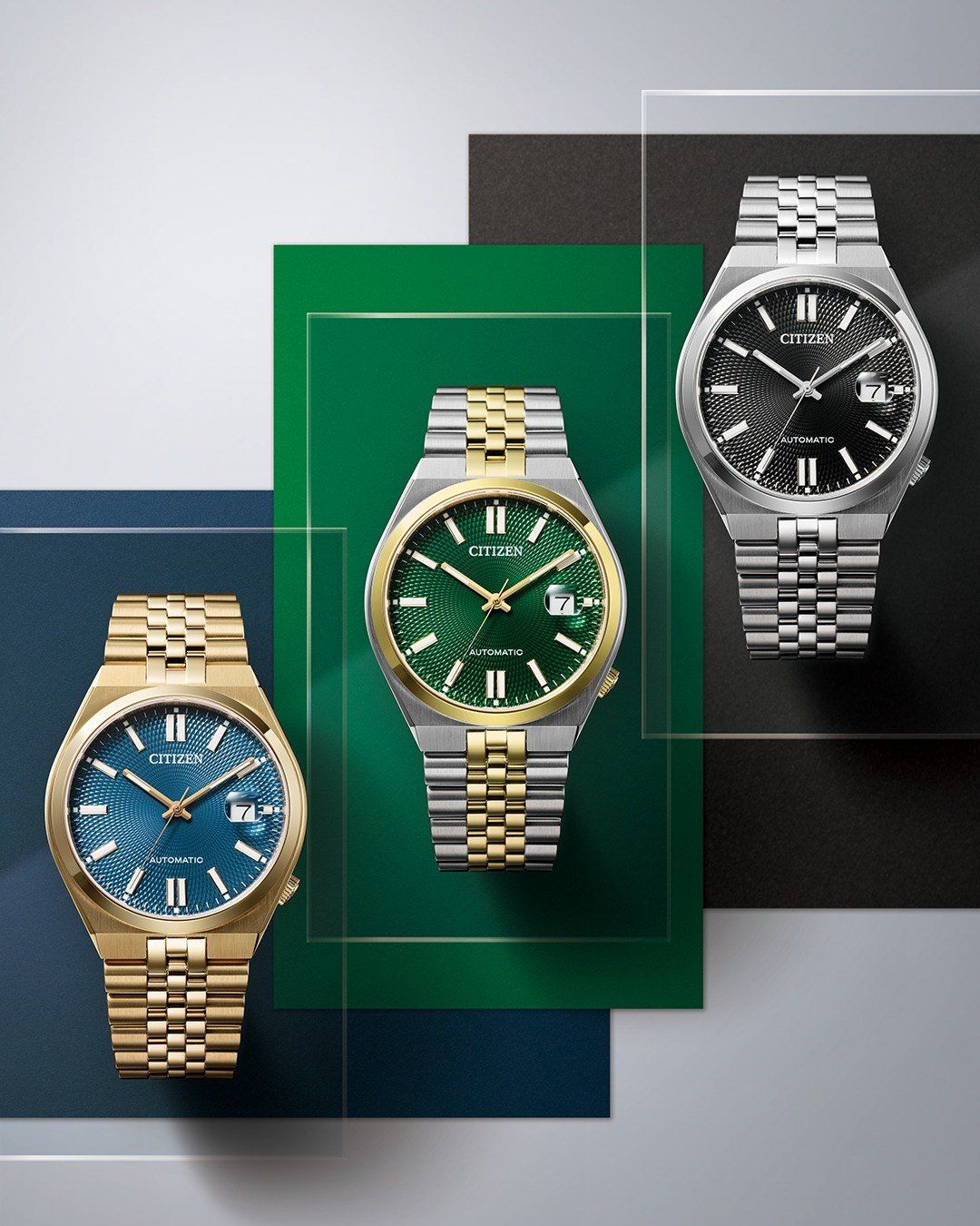 Drei Citizen-Uhren auf grünem und blauem Hintergrund. Eine ist gold mit blauem Zifferblatt, eine andere silber mit grünem Zifferblatt und die dritte silber mit schwarzem Zifferblatt.