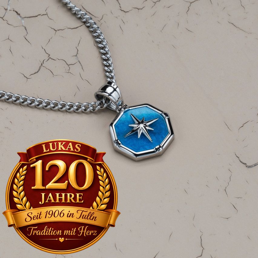 Eine silberne Kettenkette mit einem sechseckigen Anhänger, der ein Sterndesign und das Markenlogo 'Lukas 120 Jahre' zeigt.