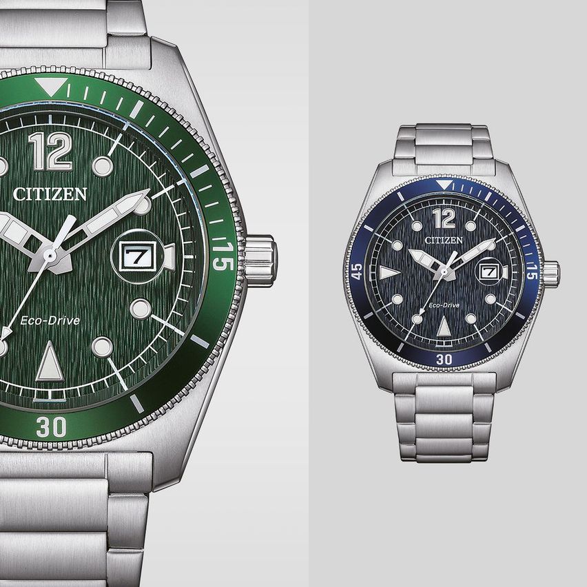 Zwei Citizen Eco-Drive Uhren. Die linke hat ein grünes Zifferblatt mit einem silberfarbenen Armband. Die rechte hat ein blaues Zifferblatt mit einem silberfarbenen Armband. Beide zeigen die Zeit 10:10 an.