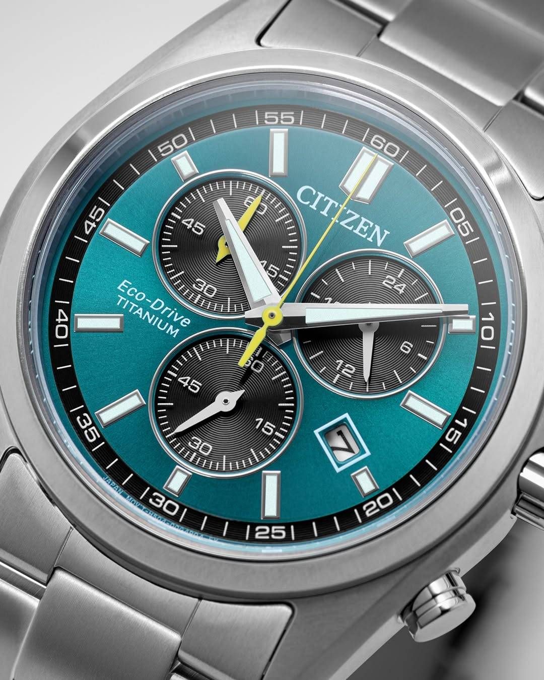 Citizen Eco-Drive Titanium Uhr mit türkisfarbenem Zifferblatt, schwarzen Hilfszifferblättern und silbernen Zeigern. Zeit steht auf 11:38, mit zusätzlichen Hilfszifferblättern für 30, 15 und 24.