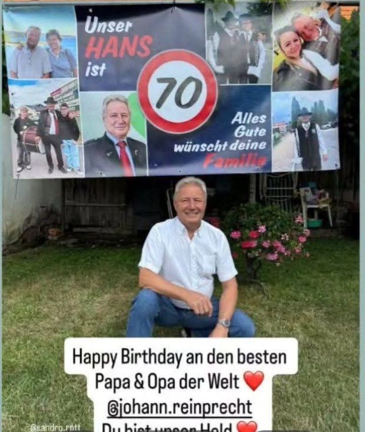 Ein Geburtstagsfoto mit einem Banner über dem Mann mit einer Geburtstagsnachricht und einem Geschwindigkeitsschild. Der Mann sitzt auf dem Rasen.
