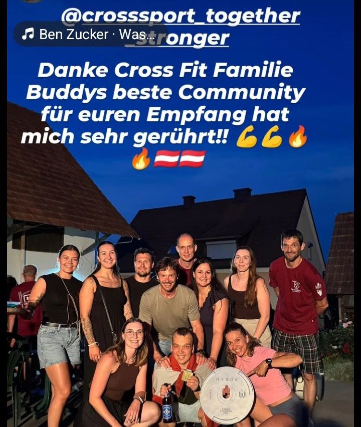 Gruppenfoto mit Ben Zuckers Lied Was Stronger im Hintergrund. Die Gruppe steht vor einem Haus mit blauem Himmel und Feuer-Emoji. Sie lächeln und posieren für die Kamera.