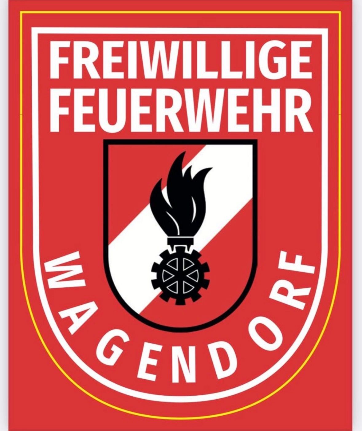 Das Logo der Freiwilligen Feuerwehr Magensdorf, mit einem roten Schild, der ein Flammen- und Zahnraddesign zeigt, umgeben von einem gelben Rand. Der Text 'MAGENDORF' ist in weiß auf rotem Hintergrund geschrieben.