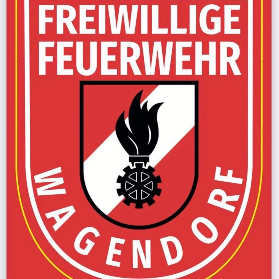 Das Logo der Freiwilligen Feuerwehr Magensdorf, mit einem roten Schild, der ein Flammen- und Zahnraddesign zeigt, umgeben von einem gelben Rand. Der Text 'MAGENDORF' ist in weiß auf rotem Hintergrund geschrieben.