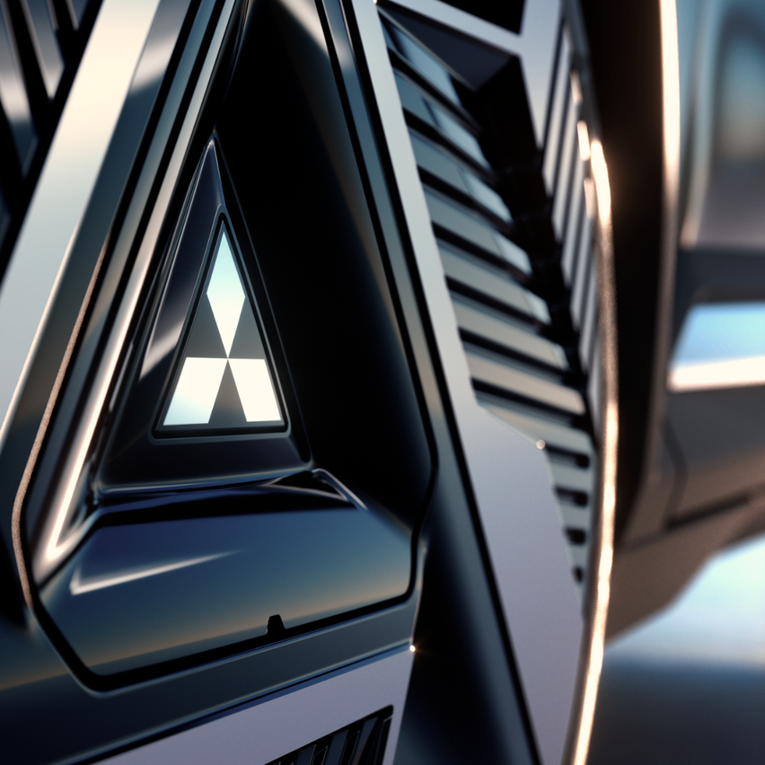 Nahaufnahme des Autogrills mit dem Mitsubishi-Logo, einem weißen Dreieck in einem größeren schwarzen Dreieck. Der Hintergrund ist unscharf, wobei das Licht auf den metallischen Oberflächen reflektiert.