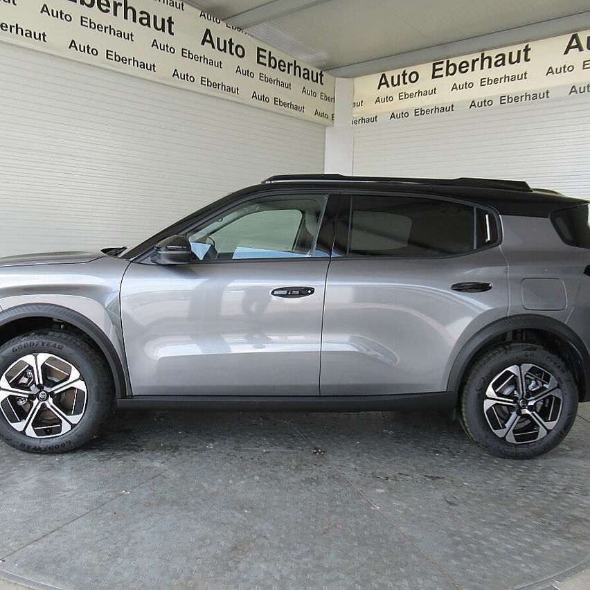 A silver SUV with alloy wheels is parked in a garage with walls that have the text 'Auto Eberhaut' written repeatedly.