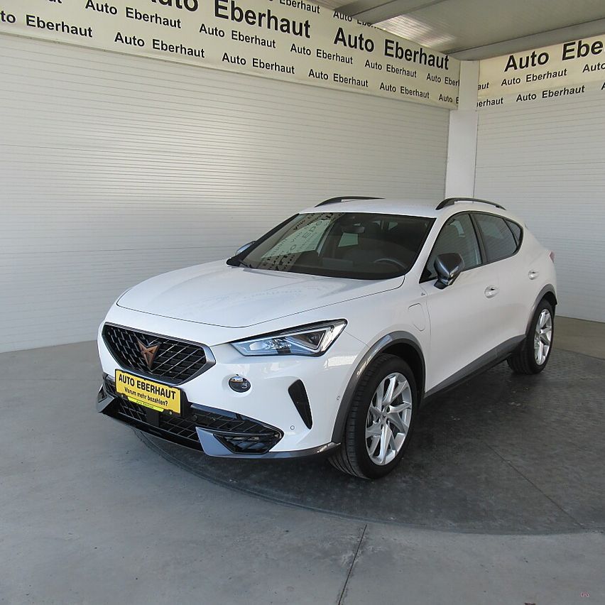 A white SUV with a yellow license plate is parked inside a showroom with a wall that has the text 'Auto Eberhaut'.