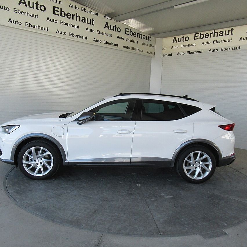 A white SUV is parked in a showroom with walls branded with the name Auto Eberhaut. The car has a sleek design and silver alloy wheels.