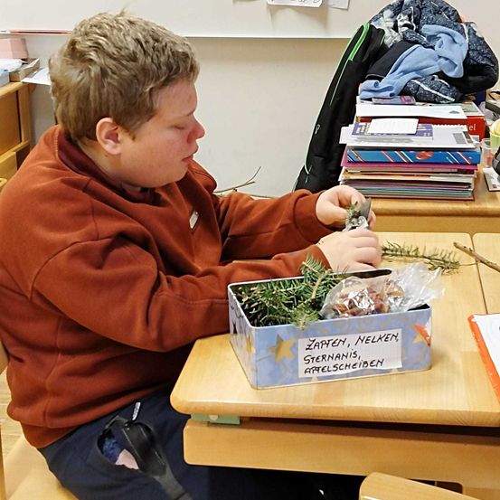 Bild enthält, Person, Sitting, Student, Scissors, Furniture, Table