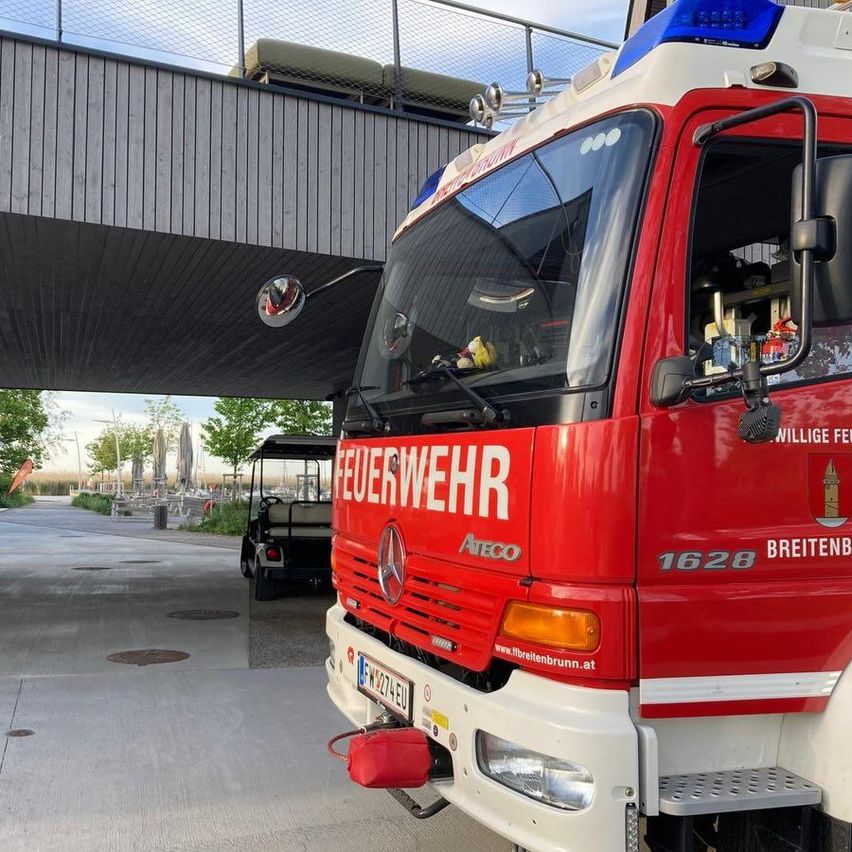 Ein roter Feuerwehrwagen mit der Nummer 1628 ist unter einer Brücke geparkt. Das Wort Feuerwehr steht an der Seite des Wagens.