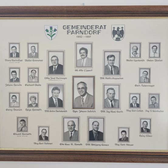 Ein gerahmtes Fotocollage des Parndorfer Gemeinderats von 1992 bis 1997, mit 18 Personen in formeller Kleidung, darunter Namen und Titel aufgeführt.