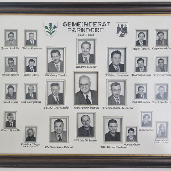 Ein gerahmtes Collage von 21 Personen, wahrscheinlich Gemeinderäte, mit ihren Namen und Dienstjahren von 1997 bis 2002. Die Collage ist von einem goldenen Rahmen umgeben und enthält ein Logo.