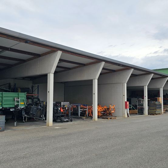 Ein großes Industrielager mit mehreren Hallen, jede mit Maschinen und Lagerausrüstung unter einem Betondach ausgestattet.
