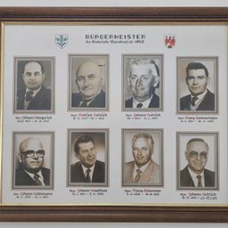 Ein gerahmtes Collage aus acht Schwarz-Weiß-Porträts von Männern, jedes mit ihren Namen und den Jahren, in denen sie als Bürgermeister einer deutschen Stadt dienten.