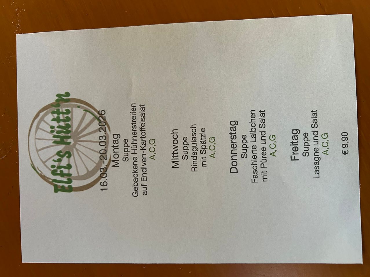 Eine weiße Seite mit einem grünen Fahrradlogo oben links. Das Datum '16.08.2026' steht links, und verschiedene Lebensmittel sind mit ihren Preisen in grünem Text aufgeführt.