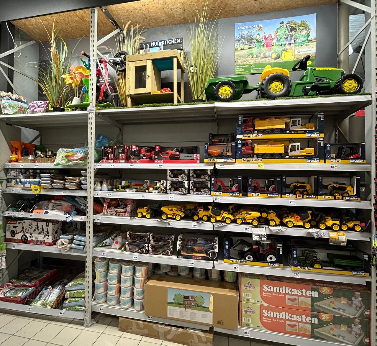 Bild enthält, Shelf, Indoors, Machine, Wheel, Person, Lawn Mower, Plant, Shop, Box, Toy