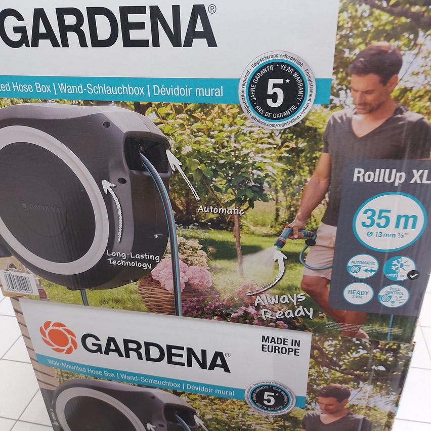 Ein Poster für GARDENA Wand-Schlauchboxen, das eine automatische einziehbare Schlauch, langlebige Technologie und 35 Meter Reichweite zeigt. Das Produkt wird als in Europa hergestellt beworben.