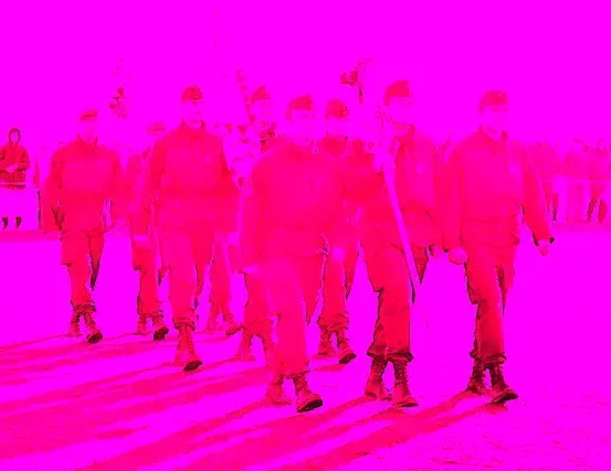 Eine Gruppe von Menschen in roten Uniformen marschiert in einer Reihe in einem rosa gefärbten Foto.