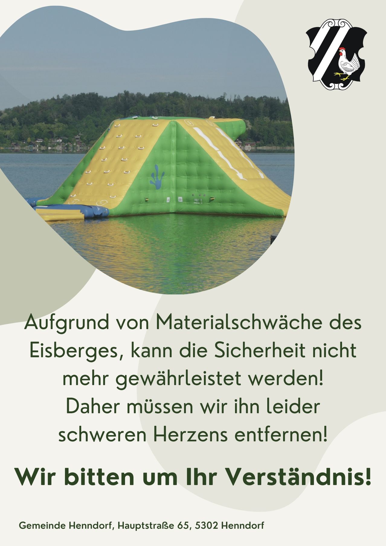 Ein aufblasbarer Wasserrutsche in Gelb und Grün schwimmt auf einem Gewässer. Die Rutsche hat eine Rutschbahn und einen Handabdruck darauf. Bäume und ein Berg sind in der Ferne.
