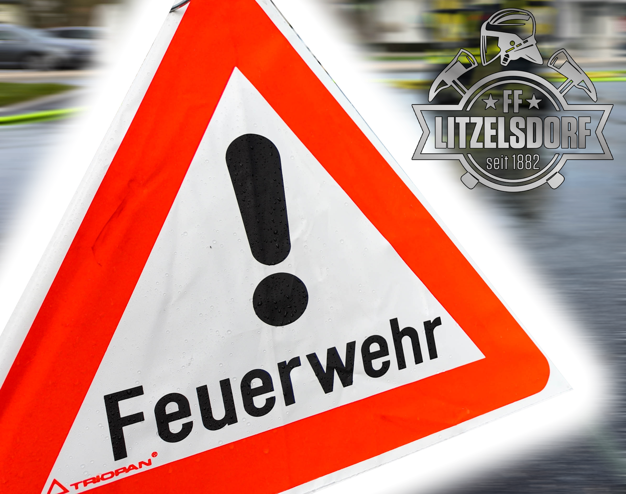 Ein deutsches Verkehrsschild mit einem roten Dreieck und einem Ausrufezeichen, das 'Feuergefahr' anzeigt. Das Schild ist nass, mit sichtbaren Wassertropfen.