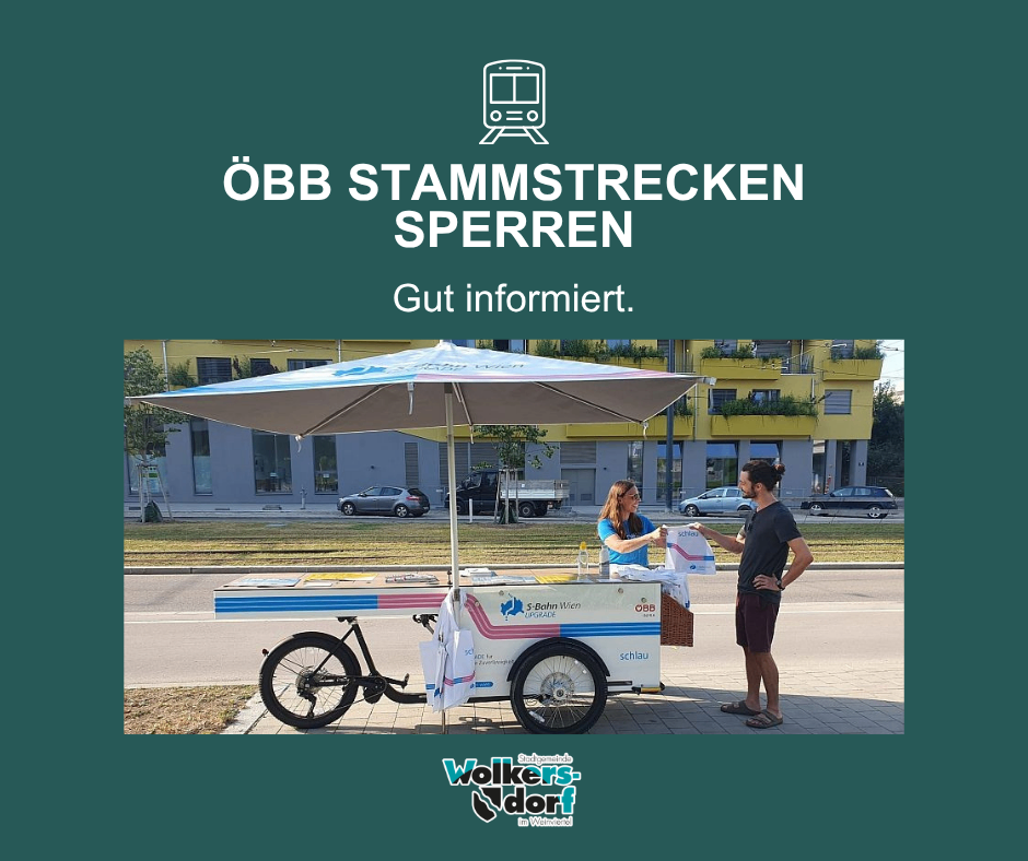 Ein Außenstand mit einem Regenschirm. Eine Frau übergibt einem Mann ein Paket. Dahinter ein Gebäude und Autos. Über dem Stand steht in Deutsch 'OBB STAMMSTRECKEN SPERRREN Gut informiert.' mit einem Straßenbahnsymbol.